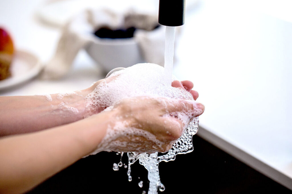Washing hands with soap at a tap