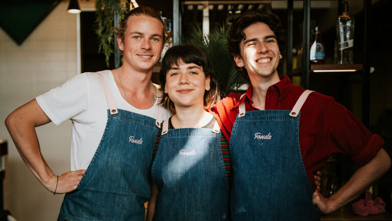 Three people wearing matching blue Fonda aprons