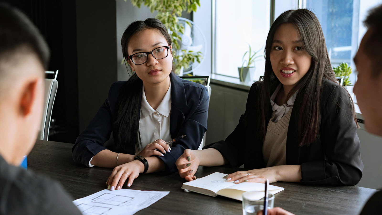 Four people sit at a meeting table