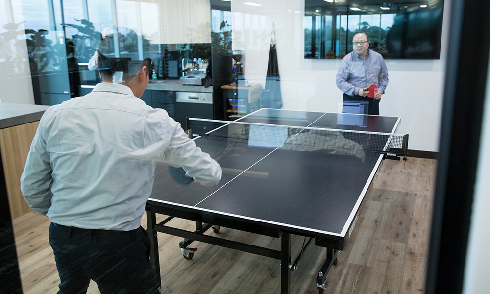 Daniel and Kevin playing table tennis at the QMetrix breakout area