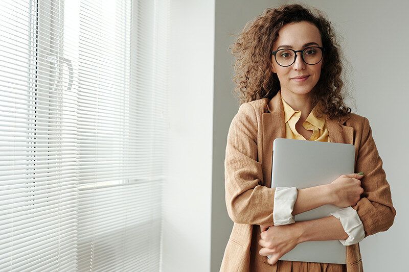 professional woman standing with laptop