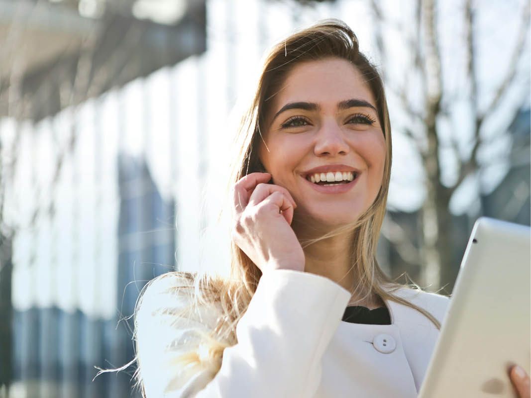 woman on the phone holding tablet smiling
