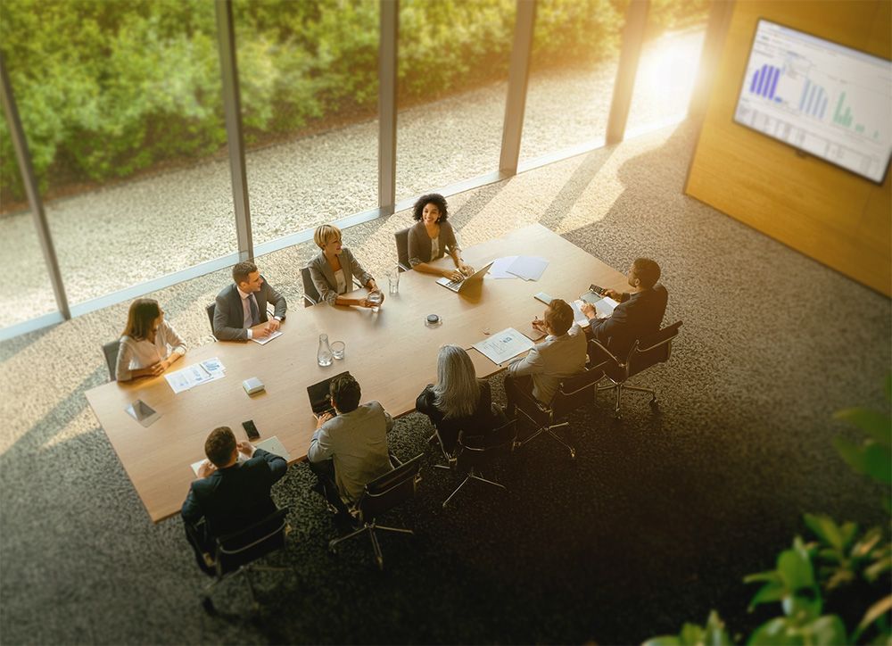 Boardroom meeting with warm natural light and visible screen
