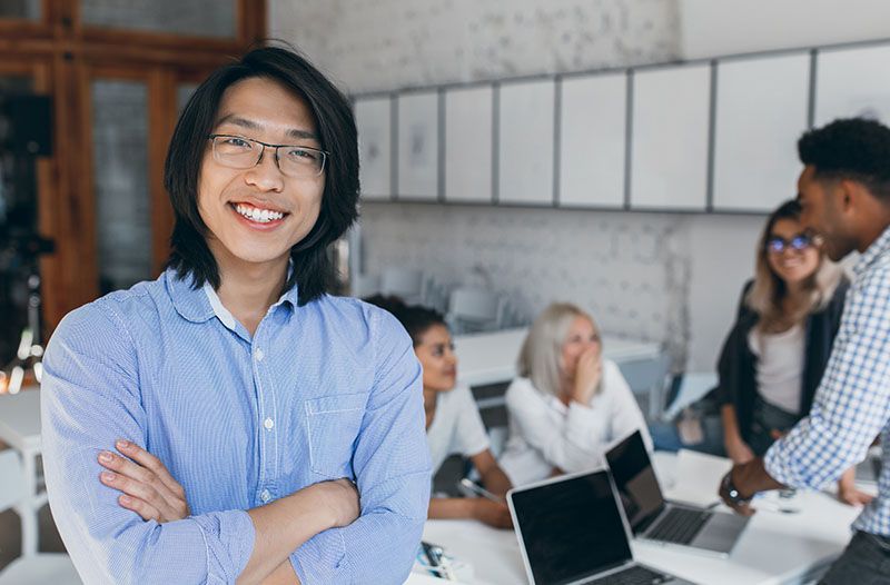 asian young man with glasses standing with arms