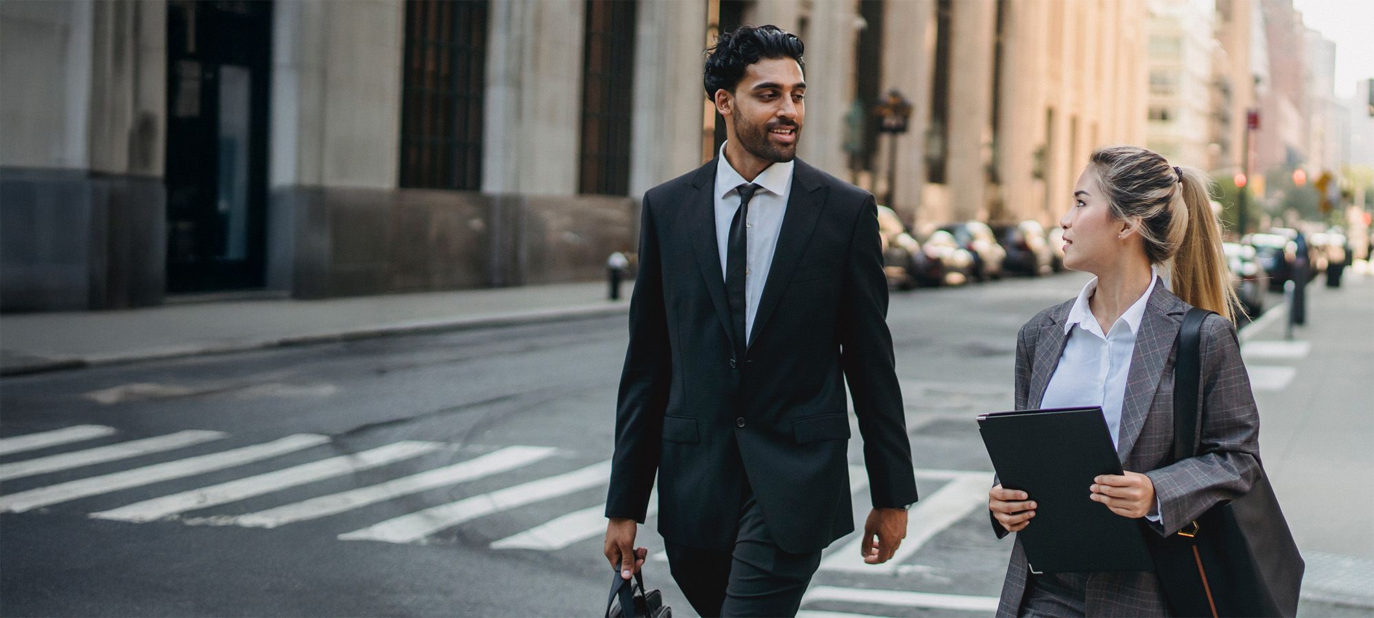two professionals crossing city road