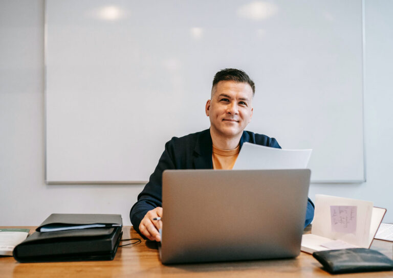 man-at-desk-laptop-smiling