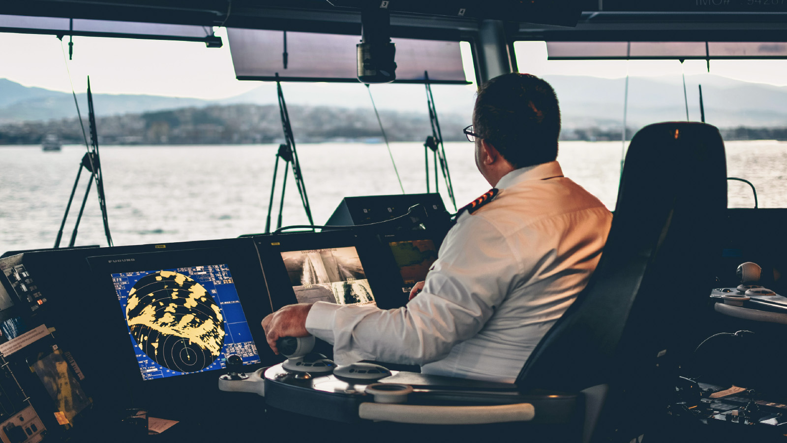 A ship captain sits at the navigation controls